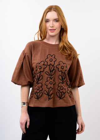 Close-up of the black floral embroidery detail on the chocolate brown knit