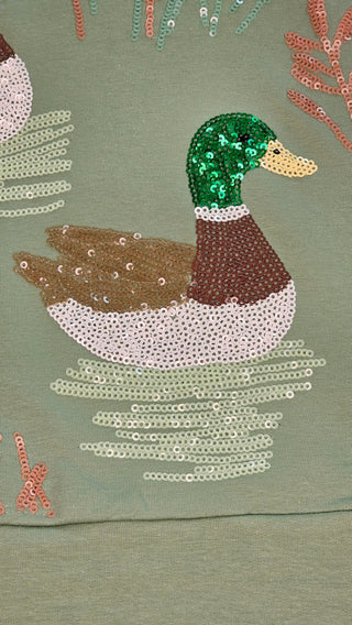 Close-up of the embroidered sequin mallard duck detail on mint green French Terry