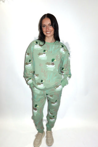 Marsh Mallard Sweatshirt in mint green with embroidered sequin ducks, worn with the matching sweatpants